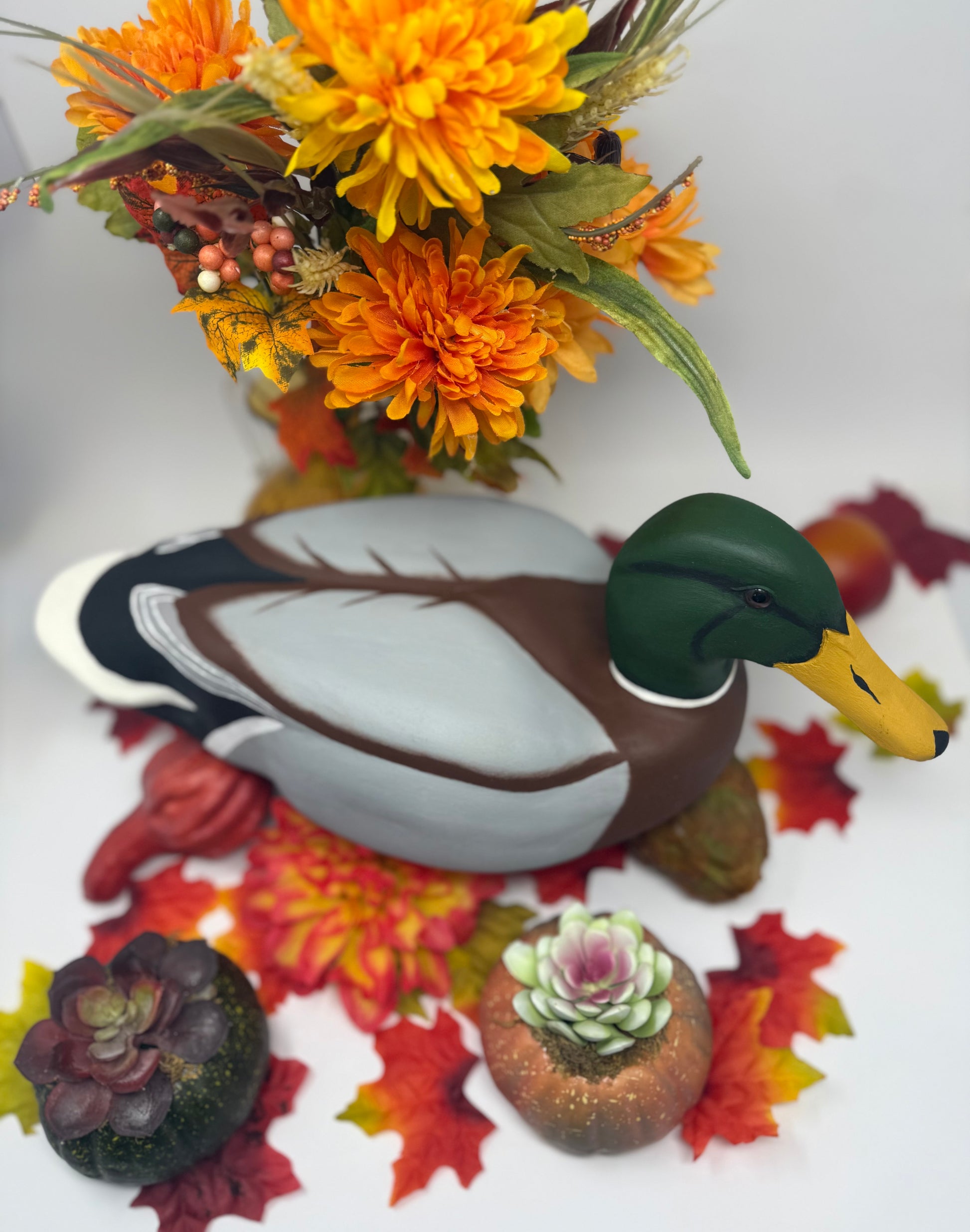 Decorative duck figurine with autumn-themed elements including flowers and leaves.