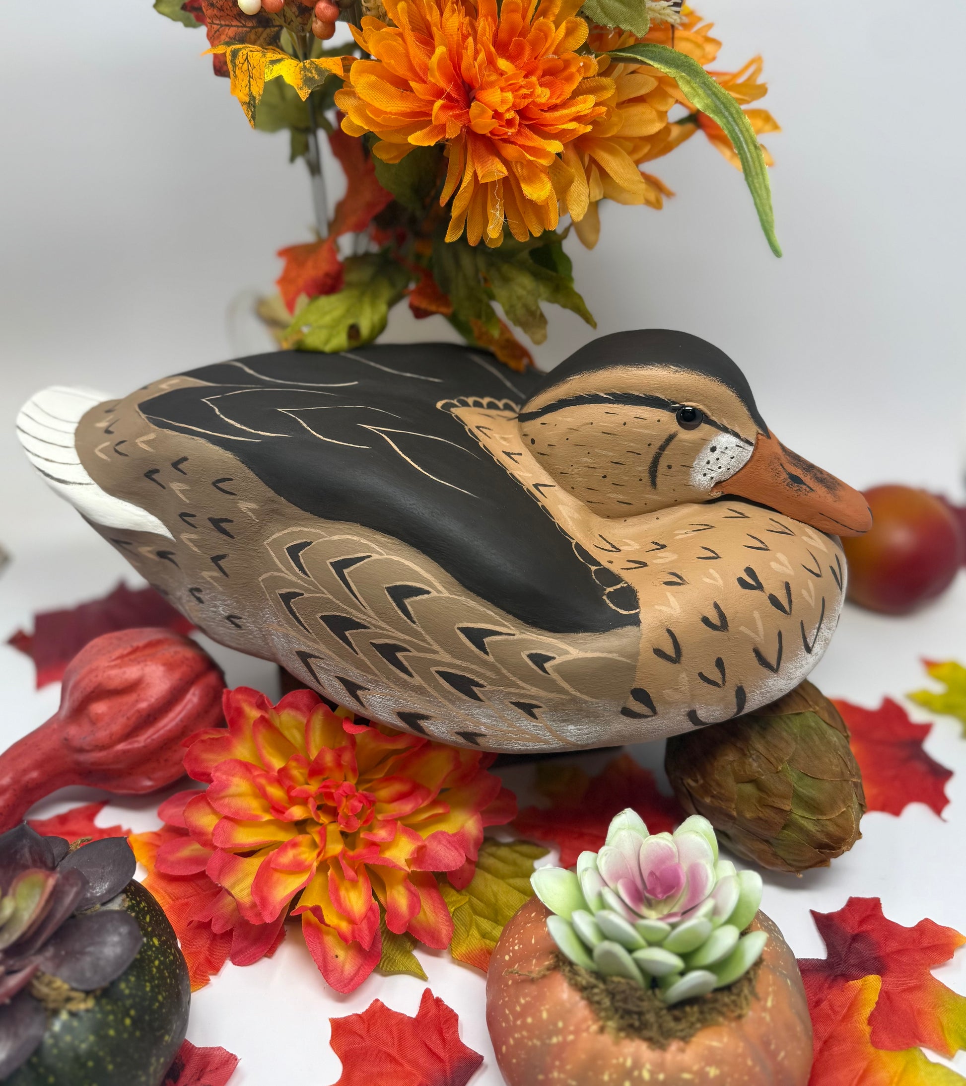 Decorative duck figurine on a table with flowers and fruits handcarved hand painted Duck decoy 